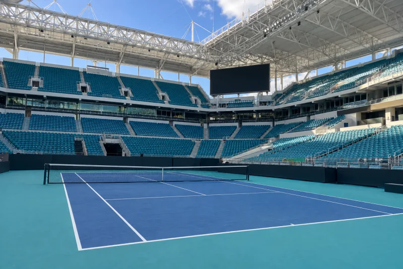 An empty tennis stadium court inside a larger stadium