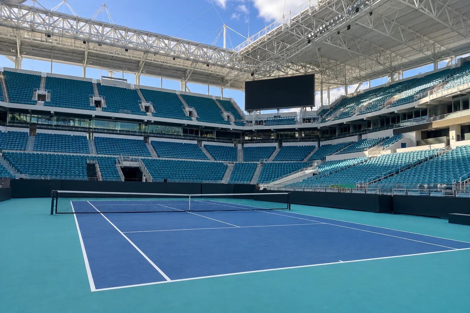 An empty tennis stadium court inside a larger stadium
