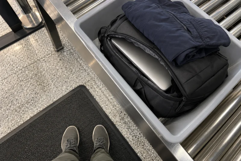 A carry-on with the laptop still inside on a security conveyor