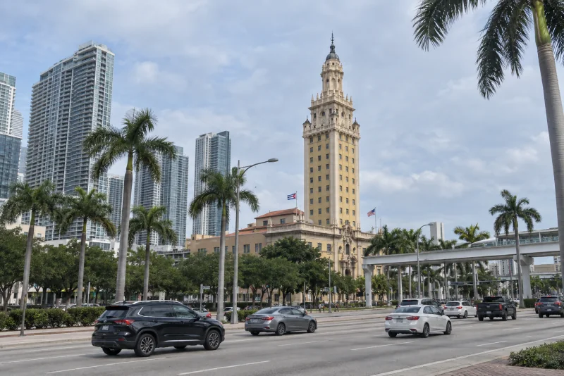 Miami's Freedom Tower on Biscayne Boulevard, with palms, traffic and the elevated Metromover guideway beside it