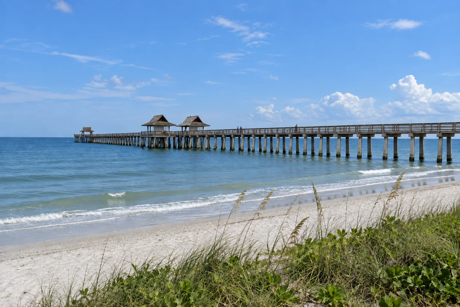 Naples Pier reaching into the Gulf of Mexico from the beach