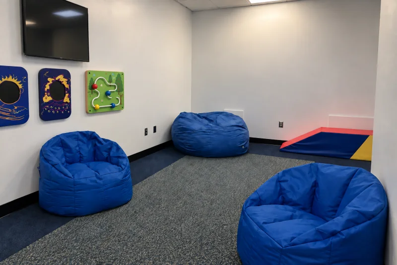 Blue beanbags and tactile wall panels in a multi-sensory room