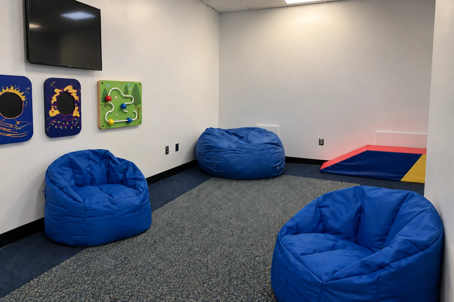 Blue beanbags and tactile wall panels in a multi-sensory room