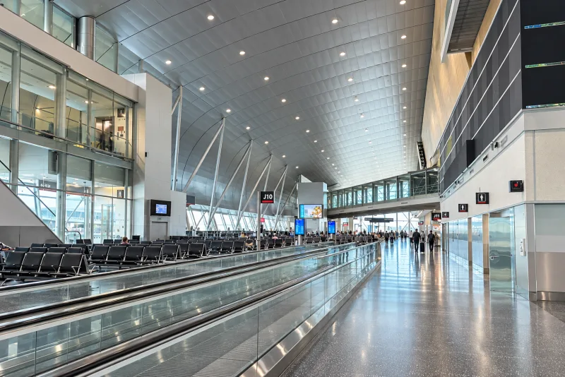 A long South Terminal concourse with gate seating and a moving walkway